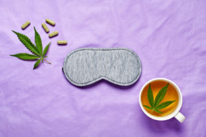 CBD for sleep represented by sleep mask and hemp leaf